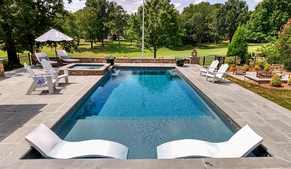 pool near green lawn with trees built by creative pools and spas